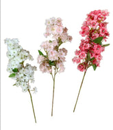 Three artificial flower branches in white, pink, and red on a white background