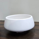 White ceramic bowl on a wooden surface with a plain background