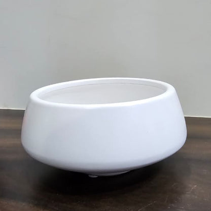 White ceramic bowl on a wooden surface with a plain background