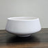 White ceramic bowl on a wooden surface with a gray background