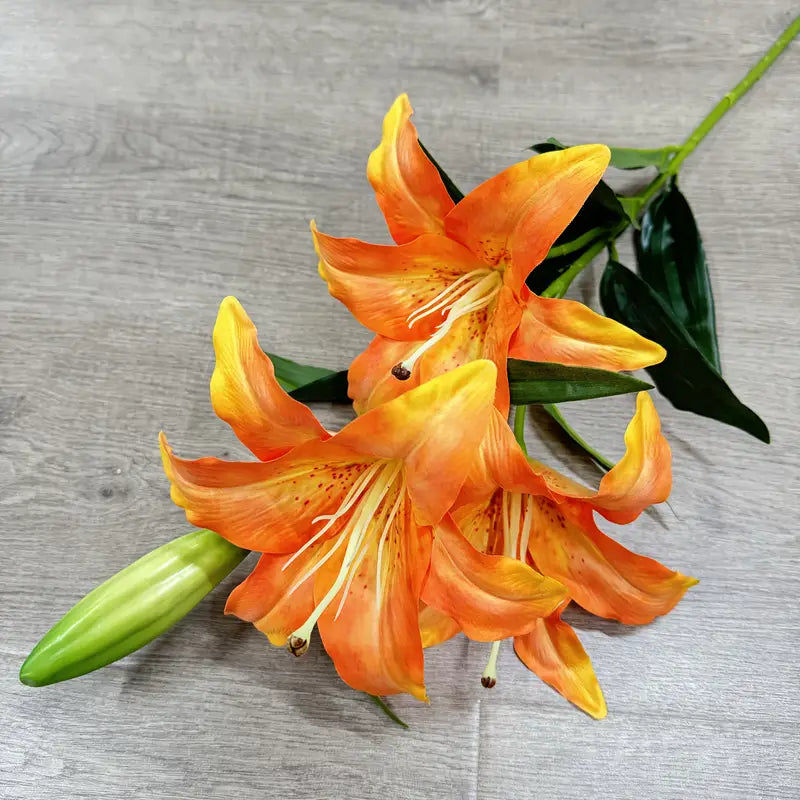 Orange lilies on a gray wooden surface