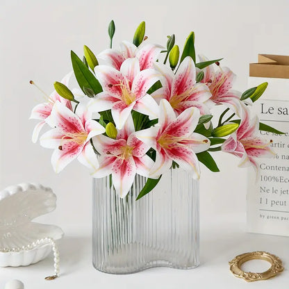 Bouquet of pink and white lilies in a clear vase on a light surface with a white background