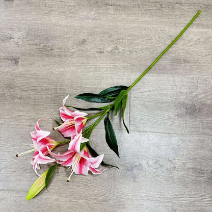 Pink lilies with green leaves on a gray wooden surface