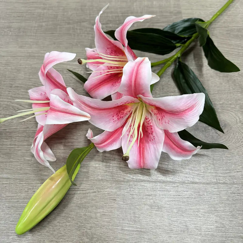 Pink and white lilies on a wooden surface