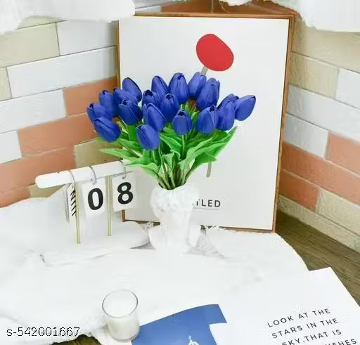 Decorative setup with blue tulips, calendar, and glass on a table.