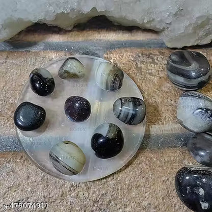 Round stone with embedded marbles on a textured surface