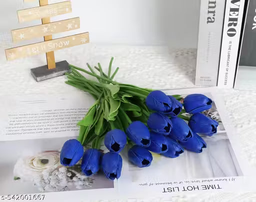 Bouquet of blue artificial tulips on a white surface with a magazine underneath