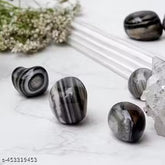Black and gray marbled earrings on a white surface with a decorative background